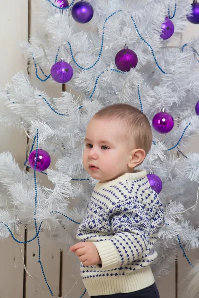 Baby boy under Christmas fir tree — Stock Photo, Image