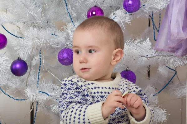 Baby boy under Christmas fir tree — Stock Photo, Image