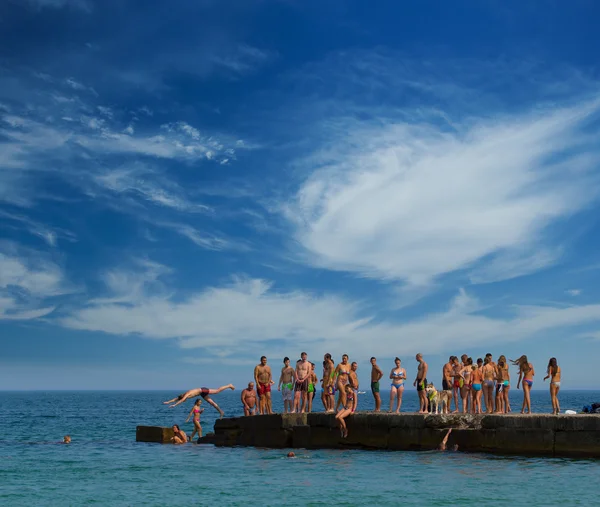 Oamenii care sar de pe dig — Fotografie, imagine de stoc