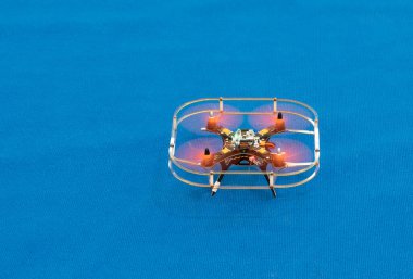 Mavi arkaplanda İHA kuadkopteri.