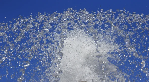 Fountain drops of pure water against a blue sky. — Stock Photo, Image