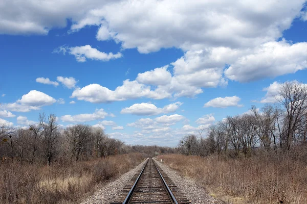 Spoorlijn naar de horizon en wolken op de hemelachtergrond. — Stockfoto