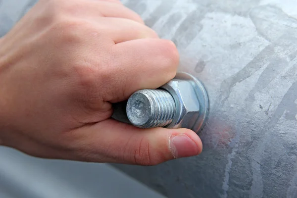 Écrou métallique au boulon à la main enroulé dans le tuyau . — Photo