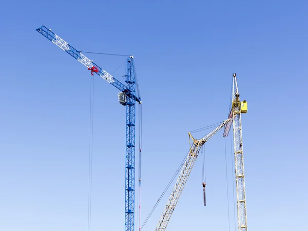 Paisaje industrial con siluetas de grúas en el cielo respaldo — Foto de Stock