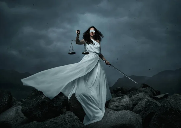 Junge Hübsche Frau Mit Waage Und Schwert Über Dramatischen Himmel lizenzfreie Stockbilder