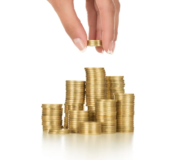 Nahaufnahme weiblicher Hand beim Stapeln von Goldmünzen auf weißem Hintergrund — Stockbild Ersparnisse — Stockfoto