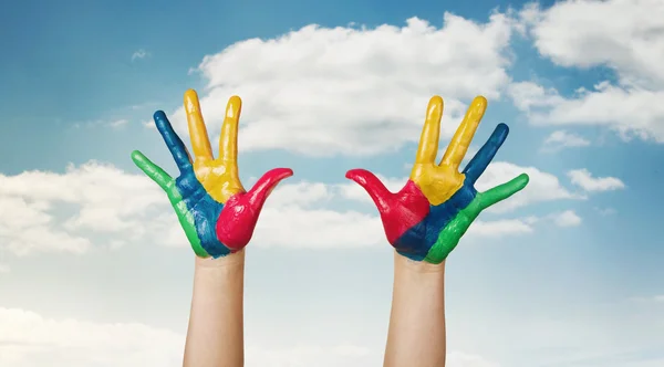 Happiness, painted colorful child's hands against the sky — Stock Photo, Image