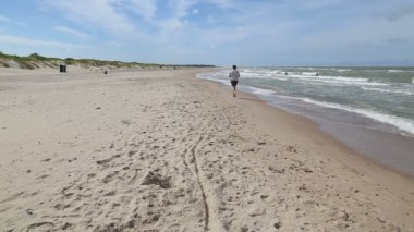 Çalışan kız Baltık Denizi kıyısında