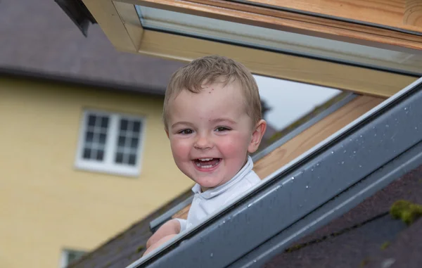 Mooie kleine babyjongen in venster — Stockfoto