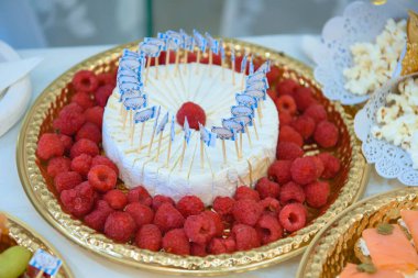 Ahududu aromalı nefis aperatif seçimi, altın tepside peynir, yemek servisi ve etkinlik promosyonları için ideal..