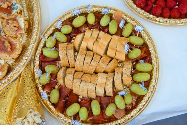 Altın tepsilerde jamon serrano, üzüm, ekmek, ceviz ve ahududu ile nefis aperatif seçimi yemek ve etkinlik promosyonları için ideal..