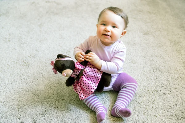 Menina bebê feliz brinca com urso de brinquedo — Fotografia de Stock