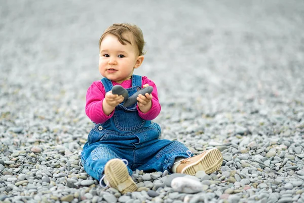 Happy one-year-old child playing on the beach