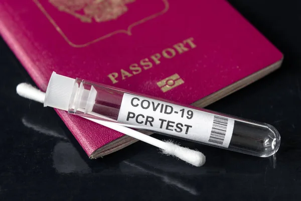 COVID-19, travel and test concept, tube and swab for PCR testing and tourist passport. Coronavirus diagnostics in airport due to restrictions. Tourism and business hit by corona virus during pandemic