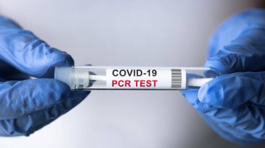 COVID-19 PCR test in doctor hands close-up, nurse in white holds coronavirus swab collection kit. Concept of corona virus diagnostics, medical testing, cure and treatment during coronavirus pandemic. clipart