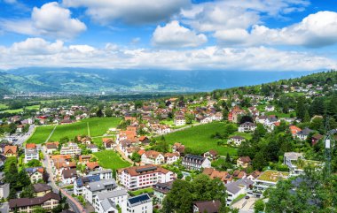 Vaduz 'lu Panorama, Lihtenştayn Prensliği. İsviçre Alpleri 'ndeki şehir manzarası. Yeşil vadi manzarası, yaz aylarında şehir ve mavi gökyüzü. Alp dağlarında Lihtenştayn 'ın silüeti.