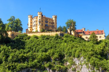Almanya 'daki Hohenschwangau Kalesi. Schloss Hohenschwangau, Bavyera Alpleri 'nin ünlü simgesidir. Eski Alman kalesinin manzarası, yazın Münih yakınlarındaki Kral II. Ludwig 'in sarayı..