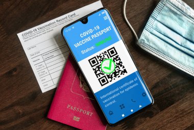 Health passport of COVID-19 vaccination in mobile phone for travel, digital passport app in smartphone. Certificate as proof of coronavirus immunization. Corona vaccine pass and COVID Record Card.