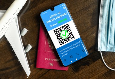 Digital health passport of COVID-19 vaccination in mobile phone for travel, vaccine passport app in smartphone. Certificate as proof of coronavirus immunization. Concept of tourism and corona pass.