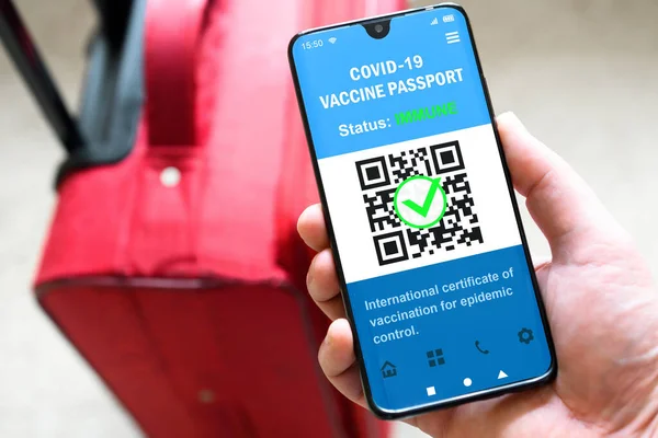 Health passport of COVID-19 vaccination in mobile phone for travel, tourist holds smartphone with passport app. Digital certificate, proof of coronavirus immunization. Corona vaccine pass and tourism.