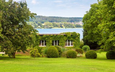 Almanya 'nın Reichenau Adası' ndaki evde bitki ve çiçeklerle peyzaj tasarımı. Constance Gölü 'ne (Bodensee) bakan güzel bir bahçe düzenlemesi. Manzaralı manzara manzaralı bahçe..