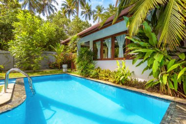 Sri Lanka - 2 Kasım 2017: Lüks tropikal otellerin veya konutların arka bahçesinde güzel bir havuz. Güzel bir yüzme havuzu ve mavi temiz su ile villa avlusunda. Ev bahçesinin peyzaj tasarımı.