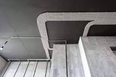 Evin tavanında elektrik kabloları ve borular var. Modern plastik hortumlar ve kablolu kanallar. Profesyonel işten sonra PVC kablo boruları hattı. Ev ya da fabrika iç dekorasyonu. 