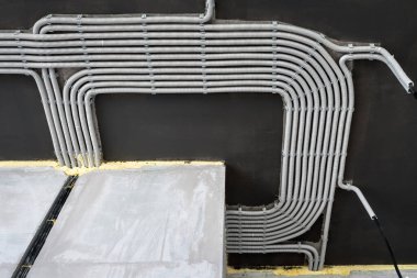 Evin tavanında elektrik kabloları ve borular var. Modern plastik hortumlar ve kablolu kanallar. Profesyonel işten sonra PVC kablo boruları hattı. Ev ya da fabrika iç dekorasyonu