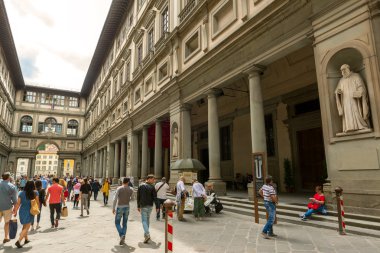 Tourists walk next to the famous Uffizi Gallery in Florence, Ita clipart