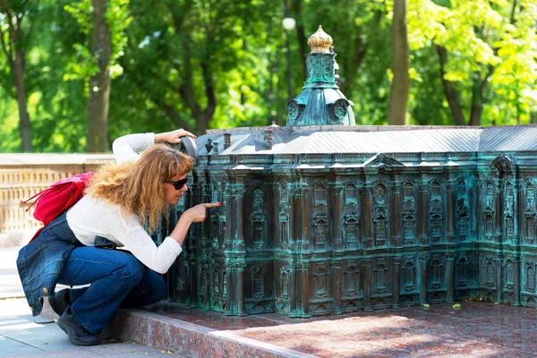 Tourist looks at a miniature copy of the Winter Palace — Stock Photo, Image