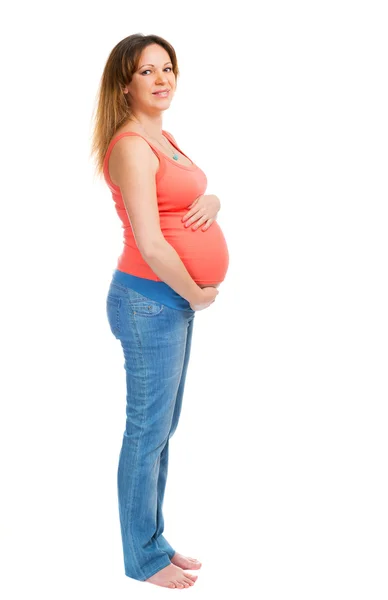 Een lachende zwangere vrouw in spijkerbroek — Stockfoto