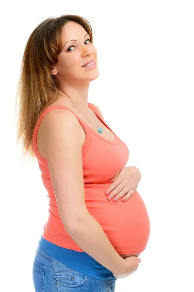 Een lachende zwangere vrouw in spijkerbroek — Stockfoto