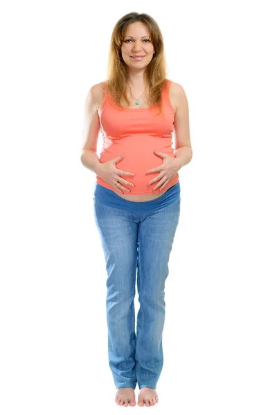 Usmívající se těhotná žena v džínách — Stock fotografie