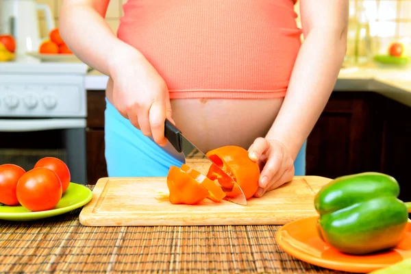 Mujer embarazada preparando comida en la cocina — Foto de Stock