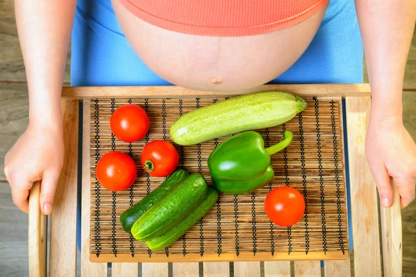 Terhes nő zöldségekkel — Stock Fotó