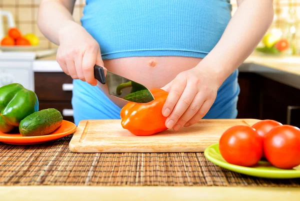 Mujer embarazada preparando una comida saludable en la cocina —  Fotos de Stock