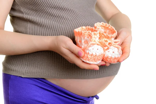 Pregnant woman holding a woolen baby shoes — Stock Photo, Image