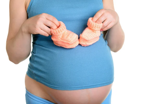 Pregnant woman holding a beautiful woolen baby shoes — Stock Photo, Image