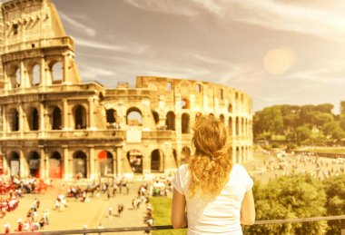 The female tourist looks at the Colosseum in Rome clipart