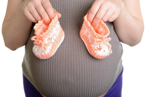 Femme enceinte tenant une belle laine chaussures de bébé — Photo