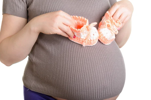 Pregnant woman holding a beautiful woolen baby shoes — Stock Photo, Image