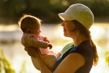 Anne bebeğini doğada basılı tutun