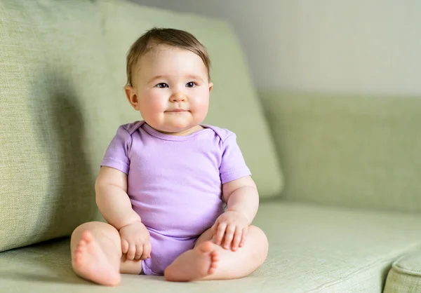 Feliz bebê sentado no sofá — Fotografia de Stock