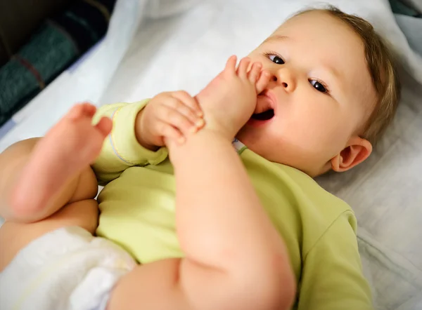 Baby hugged his leg and sucking toe — Stock Photo, Image