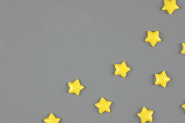 Yellow decorative stars sparse on neutral gray background — Stock Photo, Image