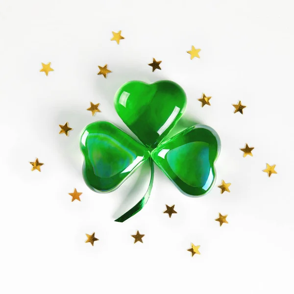Shamrock symbol made of green glass hearts lying on white background — Stock Photo, Image