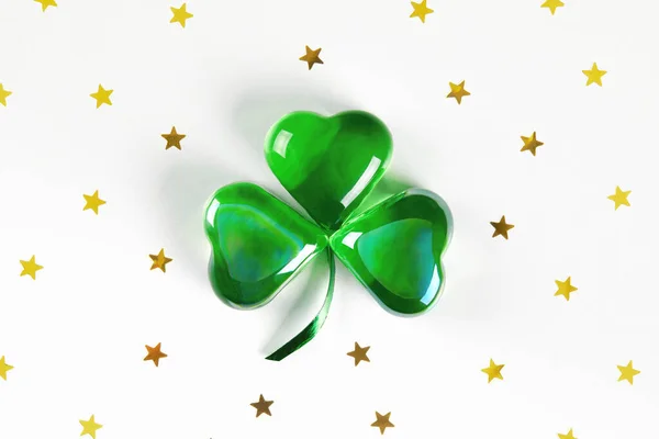 Shamrock symbol made of green glass hearts lying on white background — Stock Photo, Image