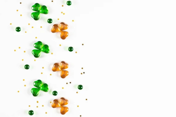 Simboli di trifoglio realizzati con cuori di vetro verde e arancione su sfondo bianco — Foto Stock