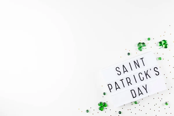 Lightbox with Saint Patricks day text and shamrocks made of green glass hearts — Stock Photo, Image
