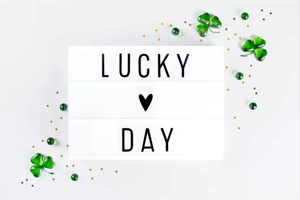 Lightbox with Saint Patricks day greeting and shamrocks of green glass hearts — Stock Photo, Image